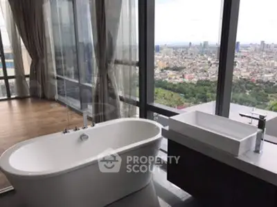 Luxurious bathroom with freestanding tub and panoramic city view.