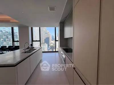 Modern kitchen with sleek design and city view, featuring an island and built-in appliances.