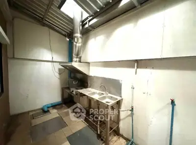 Spacious industrial-style kitchen with dual sinks and stainless steel fixtures.
