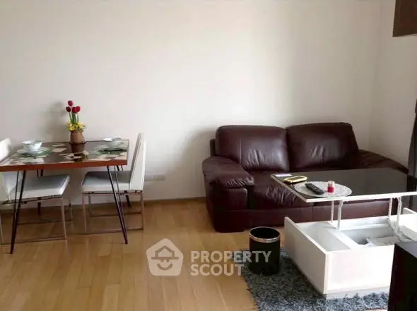 Cozy living room with leather sofa and dining area, perfect for relaxation.