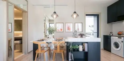 Modern kitchen with sleek design, featuring a washing machine and stylish lighting.