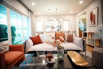 Luxurious modern living room with elegant decor and large windows offering natural light.