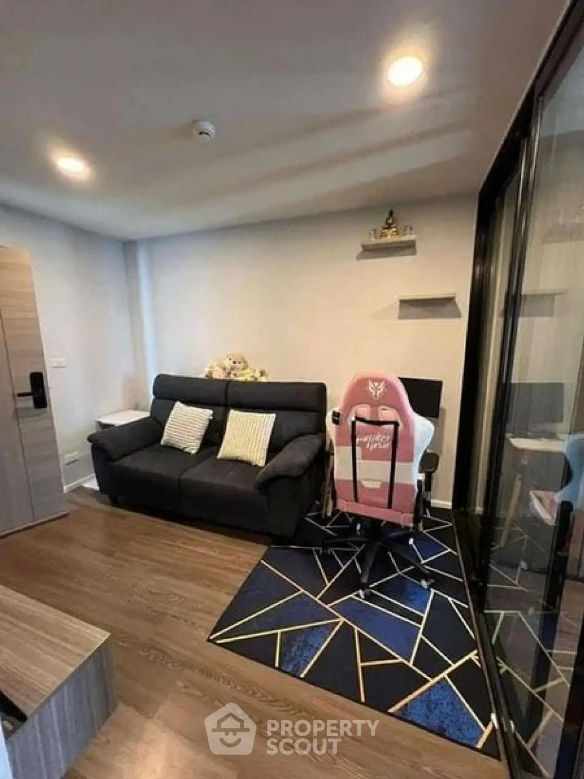 Modern living room with stylish decor and gaming chair, perfect for relaxation and entertainment.