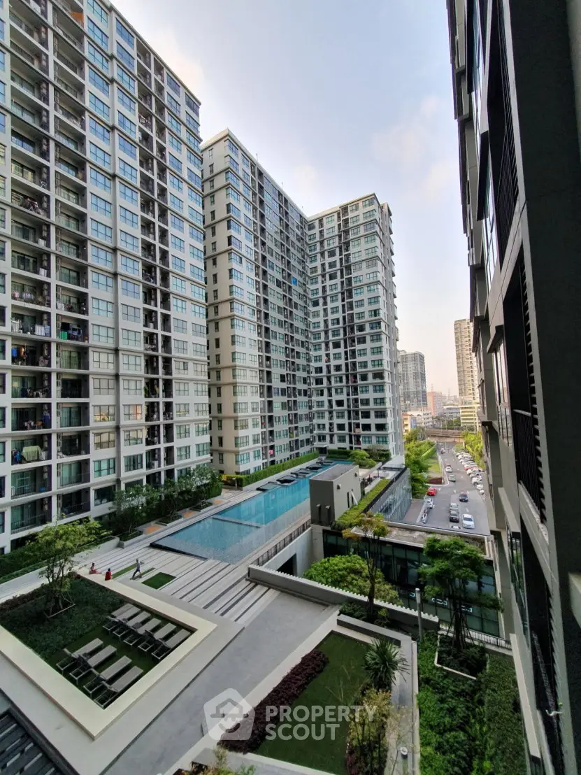 Modern high-rise apartment complex with pool and city view