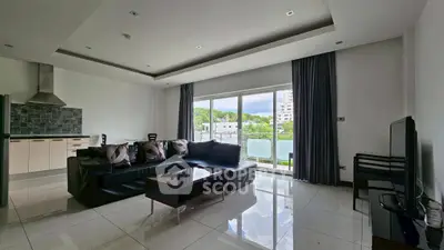 Spacious modern living room with sleek furniture and large windows offering natural light.