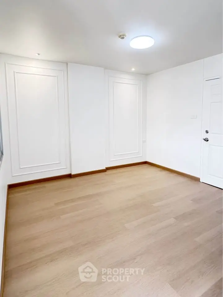 Spacious empty room with elegant white walls and wooden flooring