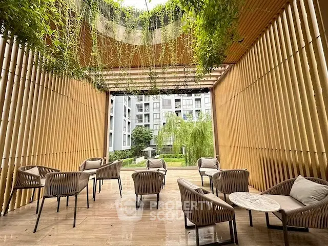 Luxurious outdoor seating area with modern design and lush greenery in a high-end residential complex.