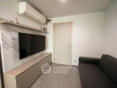Modern living room with sleek TV setup and air conditioning, featuring minimalist design and cozy seating.