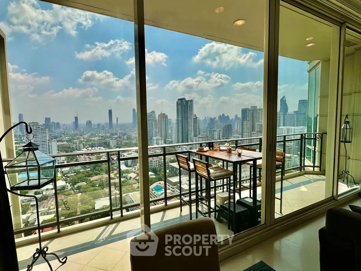 Stunning cityscape view from a high-rise balcony with elegant outdoor seating.