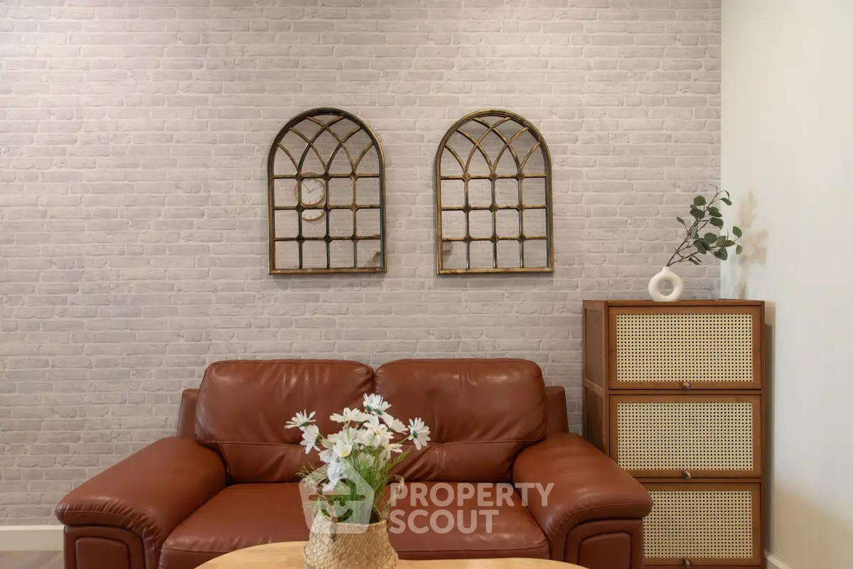 Stylish living room with leather sofa, decorative wall mirrors, and modern storage unit.