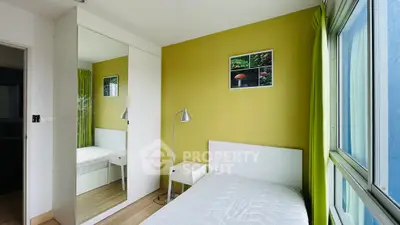 Bright bedroom with large window and mirrored closet in modern apartment