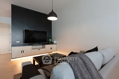 Modern living room with sleek black accent wall and cozy gray sofa.