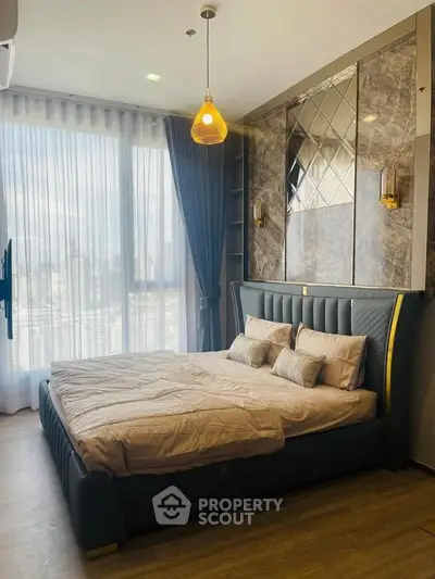 Luxurious bedroom with elegant decor and large window offering natural light.