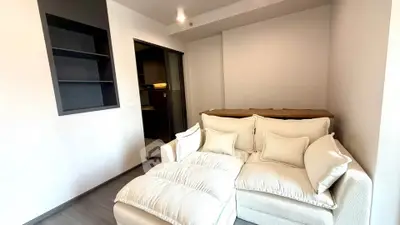 Cozy living room with plush white sofa and modern shelving, perfect for relaxation and style.