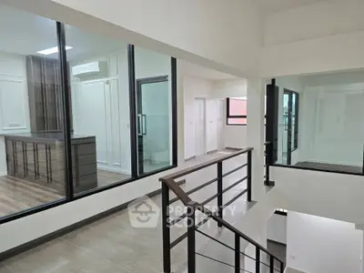 Modern interior with glass walls and sleek staircase in a contemporary home.