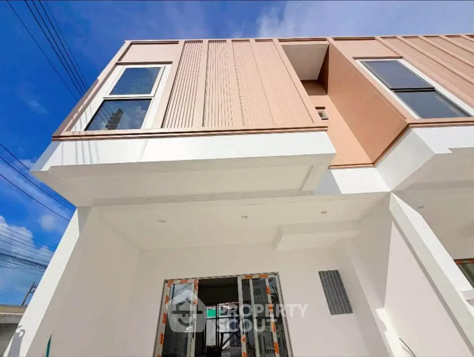 Modern two-story building with sleek design and large windows, showcasing contemporary architecture under a clear blue sky.