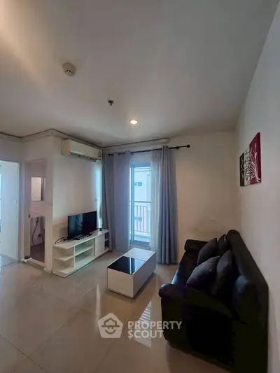 Modern living room with sleek furniture and balcony access in a stylish apartment.