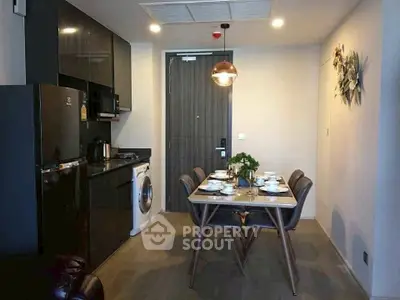 Modern kitchen with dining area featuring sleek black appliances and stylish decor.