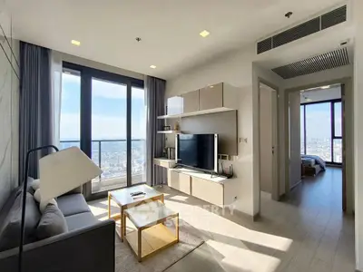 Modern living room with city view, stylish furniture, and natural light.