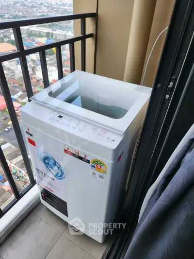 High-rise balcony with washing machine and city view, perfect for urban living convenience.