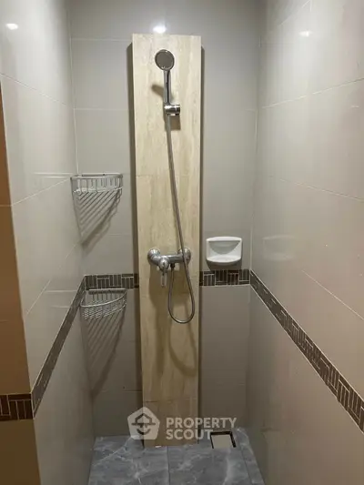 Modern bathroom shower area with sleek tile design and contemporary fixtures.