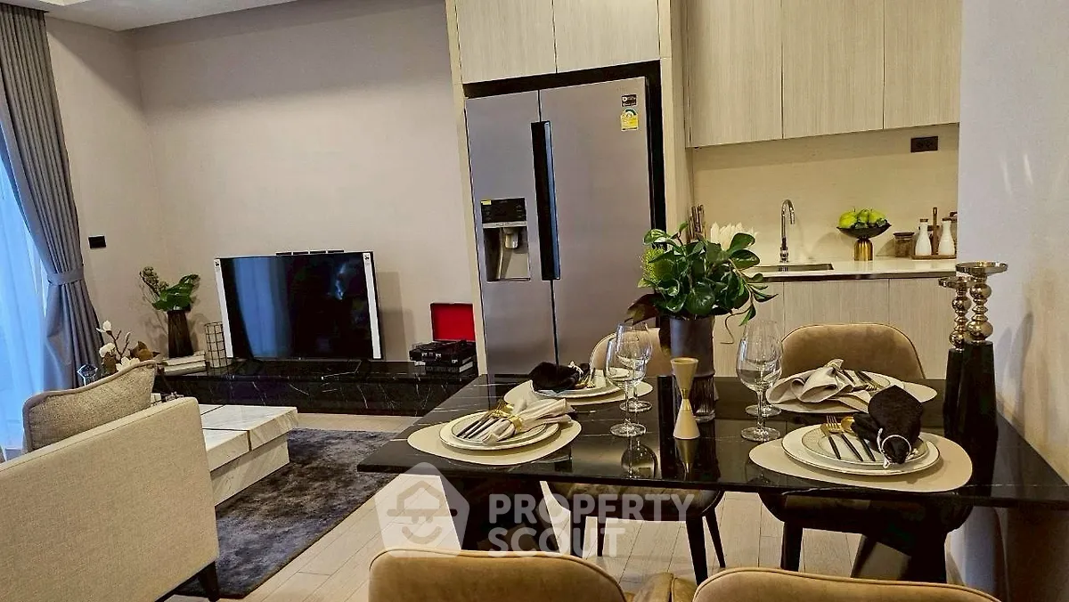 Modern open-plan living room and kitchen with elegant dining setup and sleek appliances.