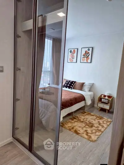 Stylish bedroom with modern decor and glass wardrobe in a cozy apartment.