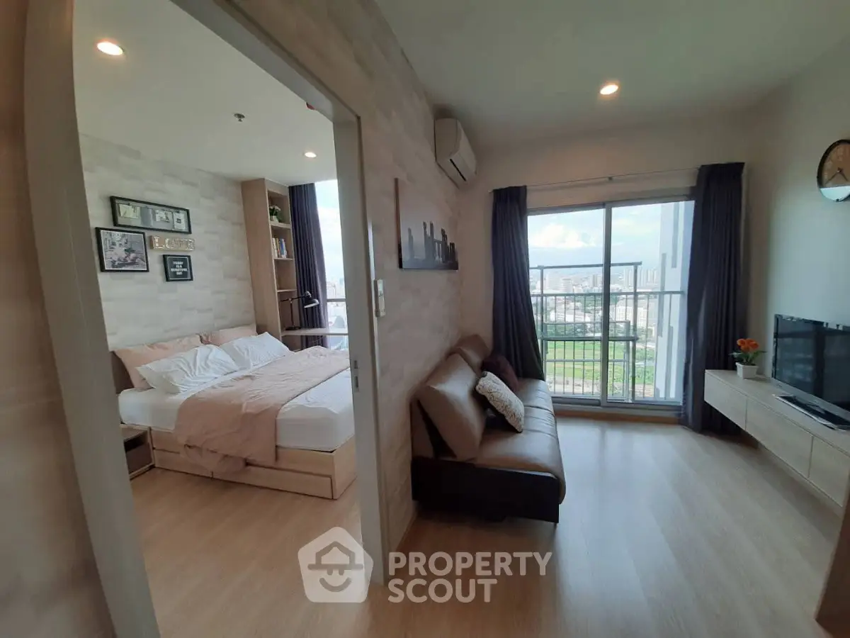 Modern apartment with cozy living room and bedroom, featuring a balcony with city view.
