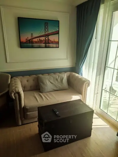 Charming living room with elegant sofa, chic decor, and natural light from large windows.