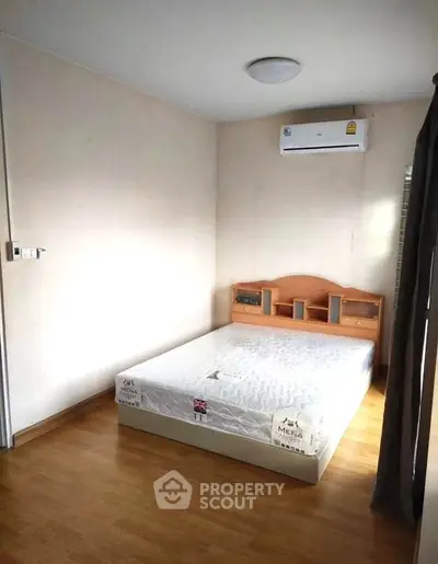 Cozy bedroom with wooden flooring and air conditioning