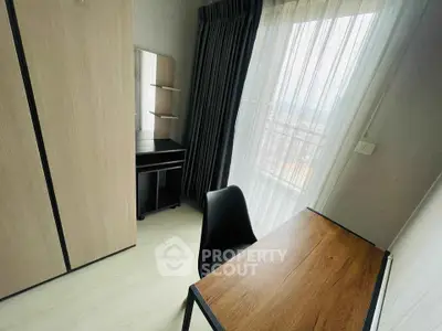 Cozy study room with wooden desk and wardrobe, featuring large window with city view.