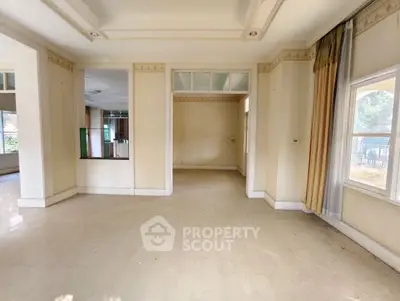Spacious empty living room with large windows and elegant curtains