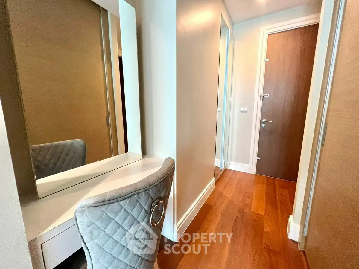 Stylish hallway with wooden flooring and elegant chair, perfect for modern living.