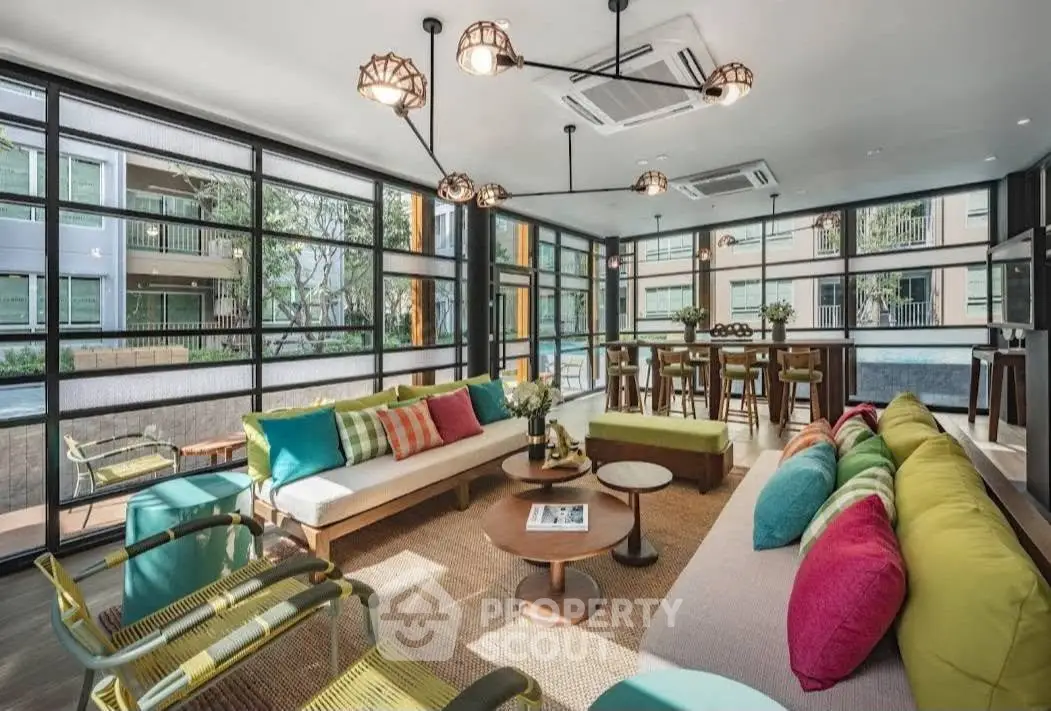 Spacious modern living room with vibrant decor and large windows offering a stunning view.