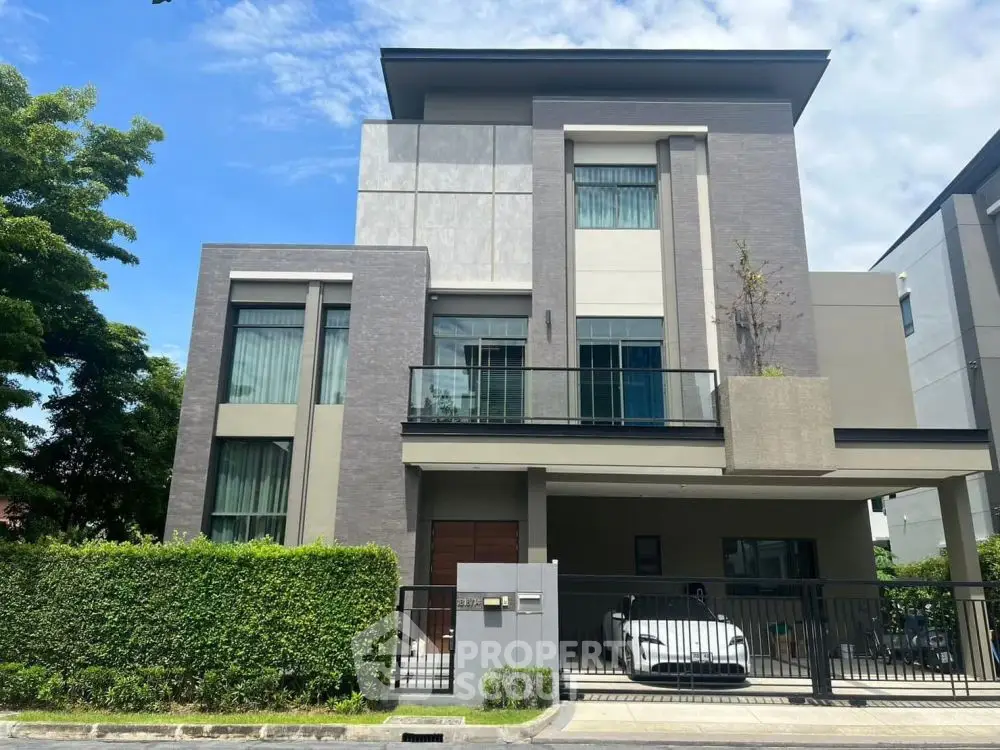 Modern three-story house with sleek design and lush greenery, featuring a spacious driveway and contemporary architecture.