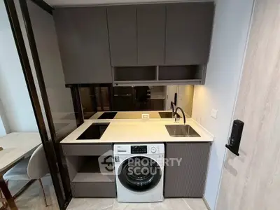 Modern compact kitchen with integrated washing machine and sleek cabinetry