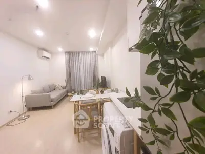 Modern living room with dining area and washing machine, featuring sleek furniture and bright lighting.