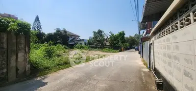 Charming residential street with lush greenery and potential for development.