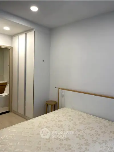 Cozy bedroom with modern wardrobe and soft lighting, perfect for relaxation.
