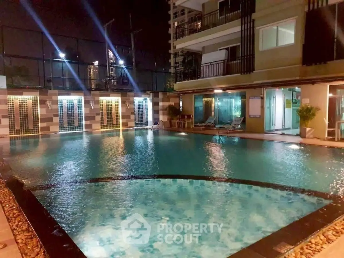Luxurious night view of a modern apartment pool area with ambient lighting.