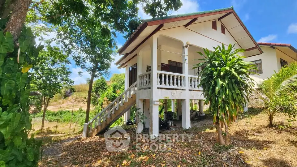 Charming elevated house with lush greenery and spacious outdoor area, perfect for nature lovers.