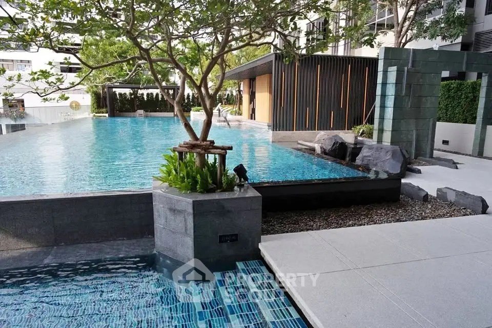 Luxurious residential pool area with modern design and lush greenery.