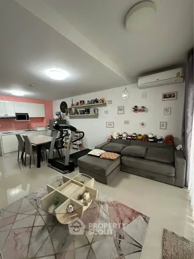 Modern living room with treadmill and stylish kitchen in open layout