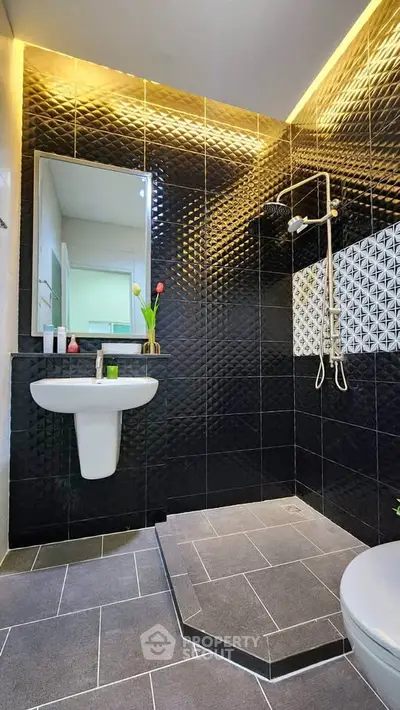Luxurious modern bathroom with black textured tiles and elegant lighting