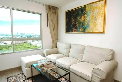 Bright living room with large window and modern art, offering stunning city views.
