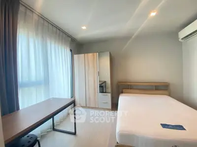 Bright and airy bedroom with modern furnishings and large window for natural light.