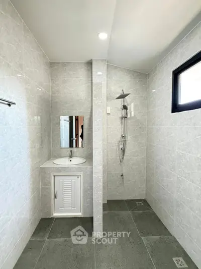Modern bathroom with sleek gray tiles and a stylish shower area.