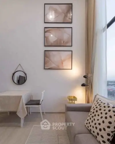 Modern living room with stylish decor, high ceilings, and large window offering natural light.