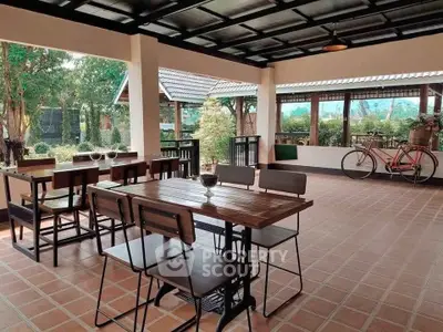 Spacious outdoor patio with dining area and scenic garden view, perfect for relaxation.
