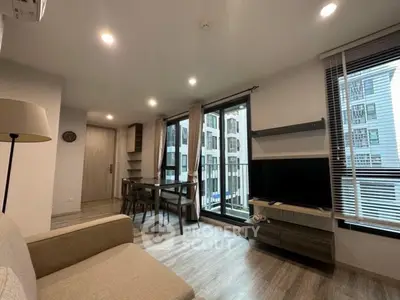 Modern living room with large windows and stylish decor in urban apartment.